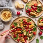 Das Foto zeigt eine lebendige Salatschüssel mit Artischocken, Kichererbsen, Kirschtomaten und roter Paprika, fein gewürzt mit "Food Finisher Salat & Bowls"