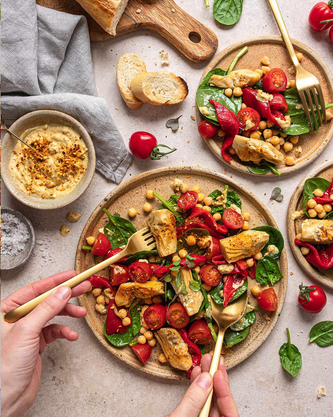 Das Foto zeigt eine lebendige Salatschüssel mit Artischocken, Kichererbsen, Kirschtomaten und roter Paprika, fein gewürzt mit "Food Finisher Salat & Bowls"
