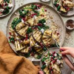 Das Foto zeigt einen Teller mit gegrilltem Auberginensalat, bestreut mit Espresso BBQ Food Finisher, und garniert mit frischen Granatapfelkernen nach Rezept.