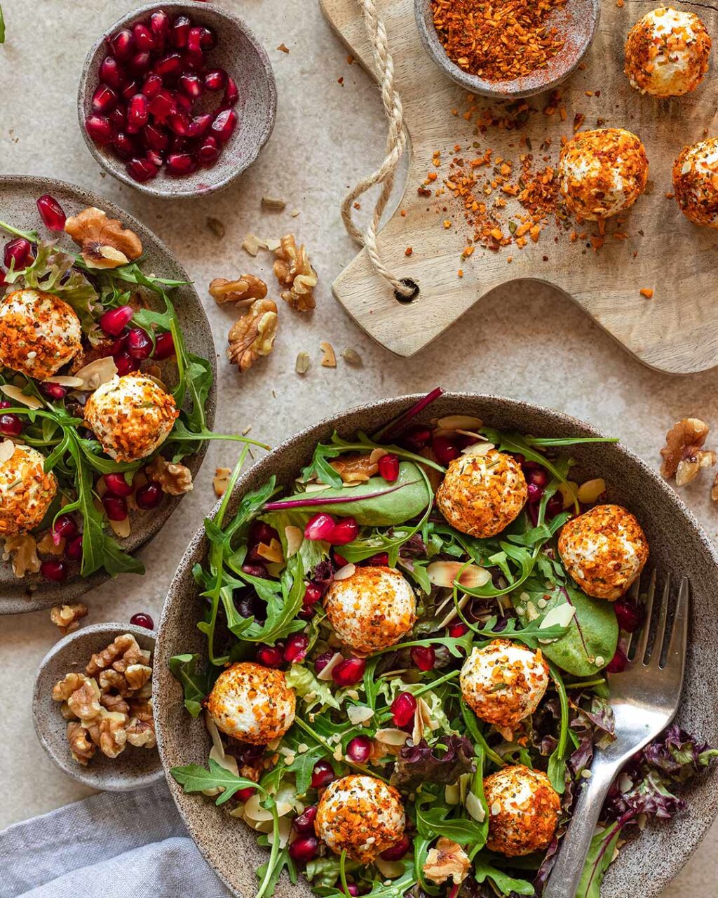 Das Foto zeigt eine Salat Bowl, bestreut mit "Food Finisher Salat & Bowls", mit veganem Feta, Rucola, Granatapfelkernen und Walnüssen.