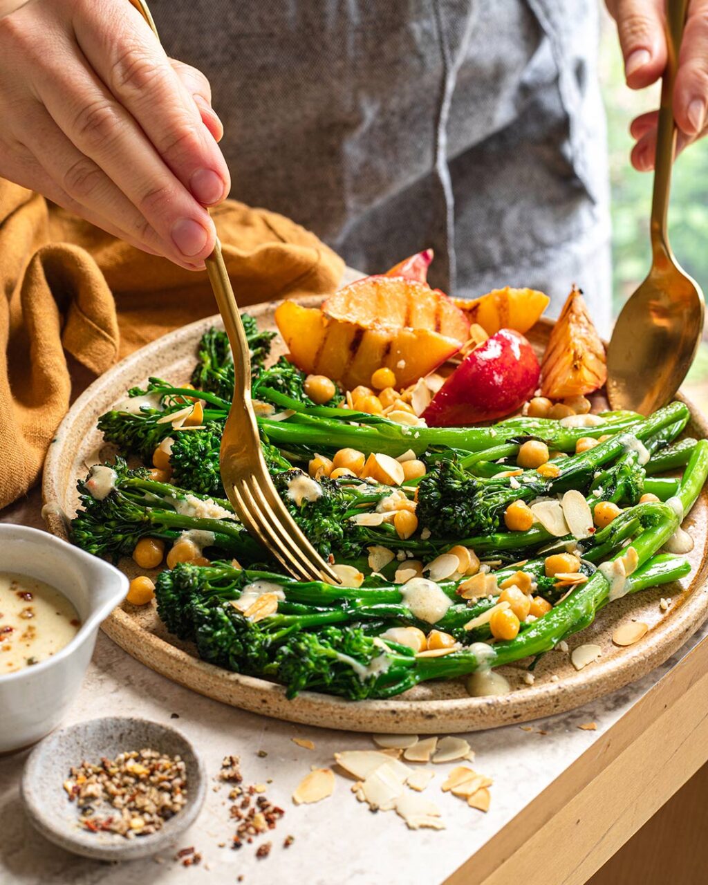 Warmer Brokkoli-Kichererbsen-Salat mit Braten-Magic-Sauce nach Rezept, garniert mit Nektarinen und Mandelblättchen.