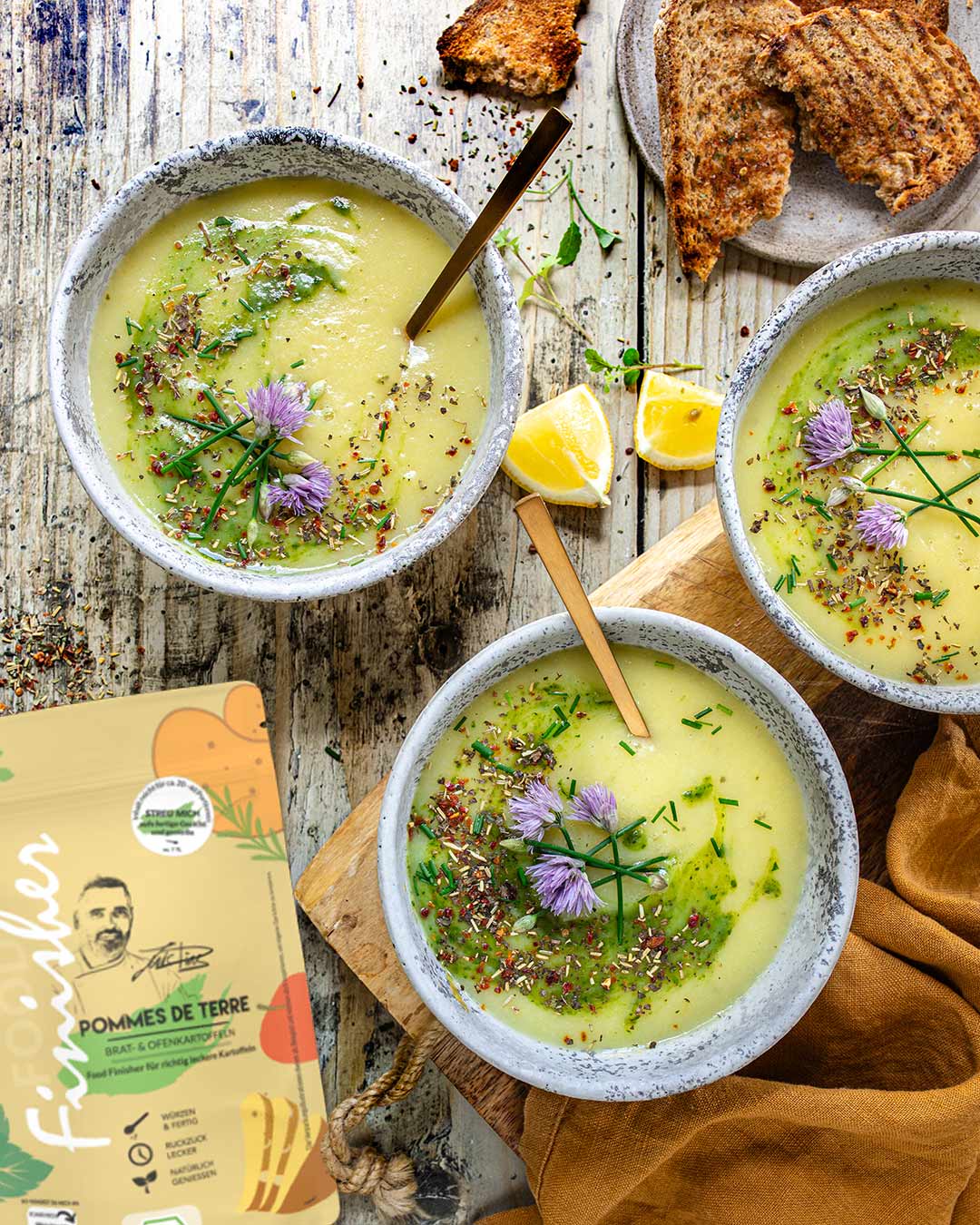 Das Foto zeigt eine cremige Kartoffelsuppe nach Rezept, garniert mit Kräutern und Blüten, gewürzt mit BIO POMMES DE TERRE FOOD FINISHER von Luis Dias.