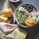 Ein Kühlschrank mit sorgfältig organisierten Lebensmitteln in Glasbehältern und wiederverwendbaren Verpackungen, begleitet von frischen Kräutern und Gemüse. Perfekte Vorbereitung, um die Haltbarkeit der Lebensmittel zu verlängern