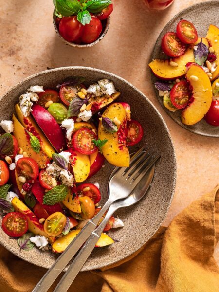 Köstlich gegrillter Pfirsichsalat mit cremigem Feta, knackigen Kirschtomaten und einem leckeren Dressing, verfeinert mit dem Bio Pommes de Terre Food Finisher von Luis Dias!