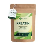 Das Bild zeigt eine Verpackung mit dem Titel "Kreatin Monohydrat" und der Beschriftung "99,9% Reinheit". Auf der Verpackung sind außerdem die Eigenschaften des Produkts beschrieben, darunter "Made in Germany", "Vegan" und "Laborgeprüft". Die Verpackung ist in natürlichen Farben gehalten, was die Nachhaltigkeit des Produkts betont. Das Produkt gehört zur Marke Vetain und vermittelt eine klare Botschaft von Reinheit und Qualität durch das minimalistische und umweltfreundliche Design.