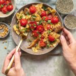 Glutenfreie, geröstete Tomatennudeln von Felicia mit veganer Hähnchen Alternative. Getoppt mit Pinienkernen und Basilikum und verfeinert mit dem Bio Tomaten Food Finisher von Luis Dias.