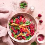 Frischer Früchte-Salat mit Wassermelone, Erdbeeren, Heidelbeeren und Minze, bestreut mit Bio Porridge Food Finisher Spices für ein sommerliches Frühstück.