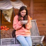 Eine Frau auf einem Bauernhof hält eine Schüssel mit köstlicher Kürbissuppe, perfekt passend zum Blogbeitrag über die gesundheitlichen Vorteile und die einfache Zubereitung von Kürbisgerichten.