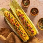 knackig gegrillter Maiskolben mit feiner Kräuterbutter und Antipasti Finisher