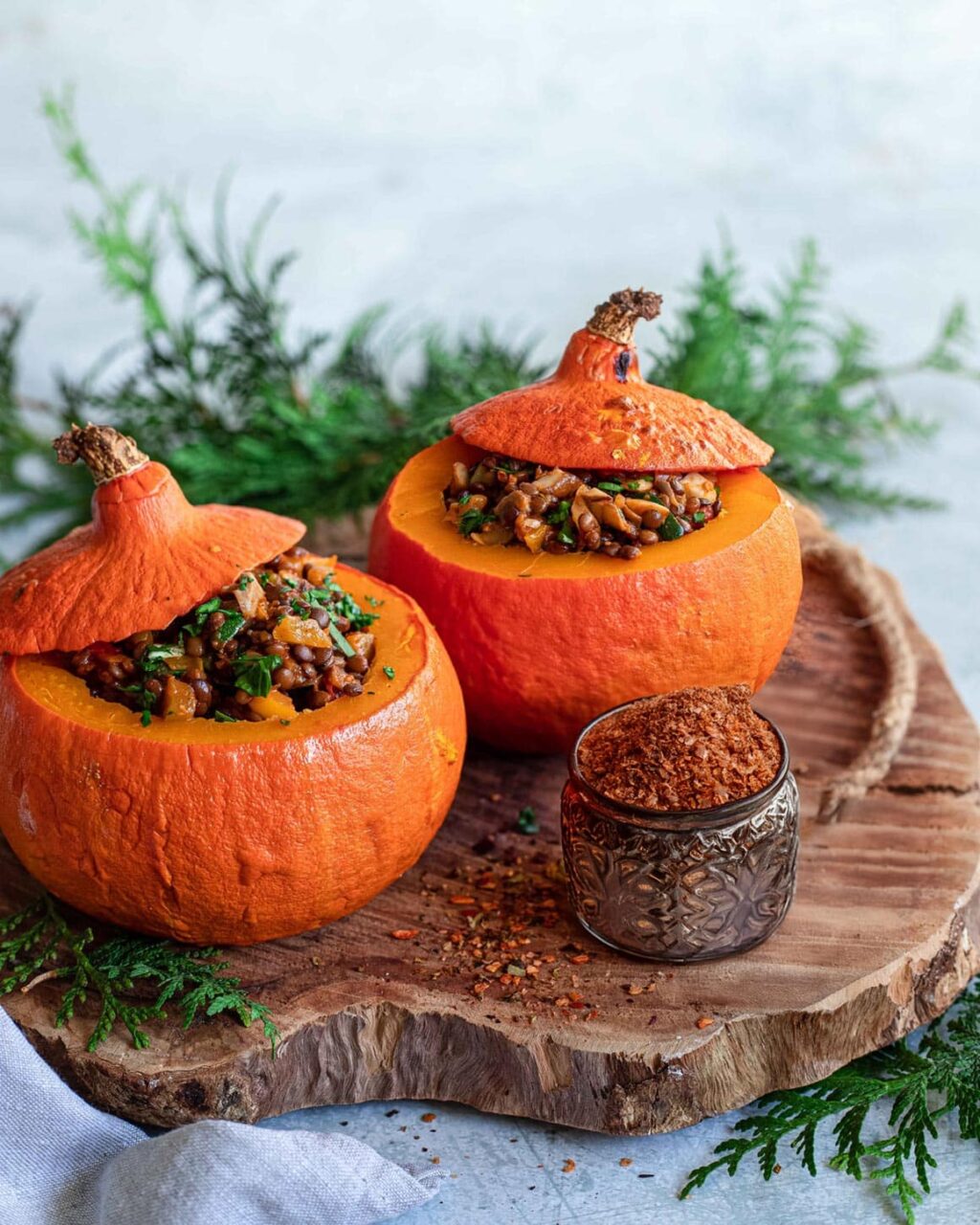 Ein herbstlicher gefüllter Kürbis, gefüllt mit einer würzigen Mischung aus Gemüse und Getreide, veredelt mit dem Aiia Food Finisher von Luis Dias. Der goldbraun gebackene Kürbis ist dekorativ angerichtet und strahlt Wärme und Geschmack aus.