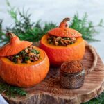 Ein herbstlicher gefüllter Kürbis, gefüllt mit einer würzigen Mischung aus Gemüse und Getreide, veredelt mit dem Aiia Food Finisher von Luis Dias. Der goldbraun gebackene Kürbis ist dekorativ angerichtet und strahlt Wärme und Geschmack aus.