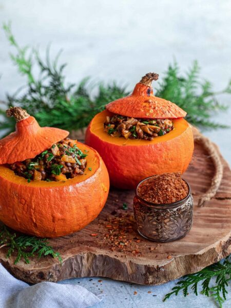 Ein herbstlicher gefüllter Kürbis, gefüllt mit einer würzigen Mischung aus Gemüse und Getreide, veredelt mit dem Aiia Food Finisher von Luis Dias. Der goldbraun gebackene Kürbis ist dekorativ angerichtet und strahlt Wärme und Geschmack aus.