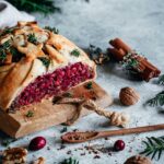 Ein saftiger veganer Nussbraten, goldbraun gebacken und verfeinert mit dem Braten Food Finisher. Das Gericht ist auf einem rustikalen Teller angerichtet, umgeben von Kräutern und einer herzhaften Sauce – ein Festtagsgericht für Genießer.