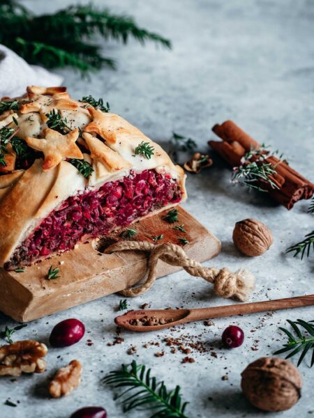 Ein saftiger veganer Nussbraten, goldbraun gebacken und verfeinert mit dem Braten Food Finisher. Das Gericht ist auf einem rustikalen Teller angerichtet, umgeben von Kräutern und einer herzhaften Sauce – ein Festtagsgericht für Genießer.