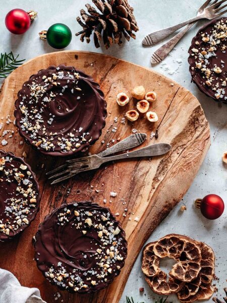 Zartschmelzende vegane Schokoladentörtchen, dekoriert mit einer Prise Gewürz-Mix Wild Food Finisher. Die Törtchen sind dunkel und glänzend, mit einer verlockenden, cremigen Textur – perfekt für besondere Anlässe oder den Genussmoment zwischendurch.