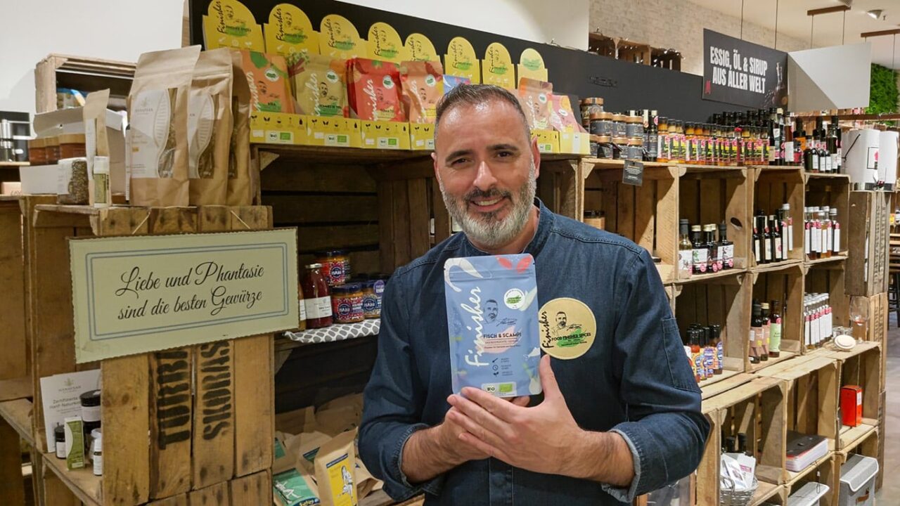 Spitzenkoch Luis Dias verfeinert im Haus der Manufakturen ein Gericht mit dem Bio Food Finisher, einer hochwertigen Gewürzmischung, die über das fertige Essen gestreut wird. Diese Mischung hebt die Aromen und sorgt für ein intensives, kulinarisches Erlebnis.