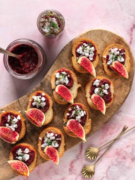Mini-Canapés auf einer Servierplatte, belegt mit Fleisch, Gemüse und aromatischen Kräutern. Verfeinert mit dem Bio Braten Food Finisher Spices. Würzige Bio-Gewürzsalz mit Pfeffer, Paprika, Chili, Rosmarin und Thymian. 100 % Bio, vegan, ohne Zusatzstoffe.