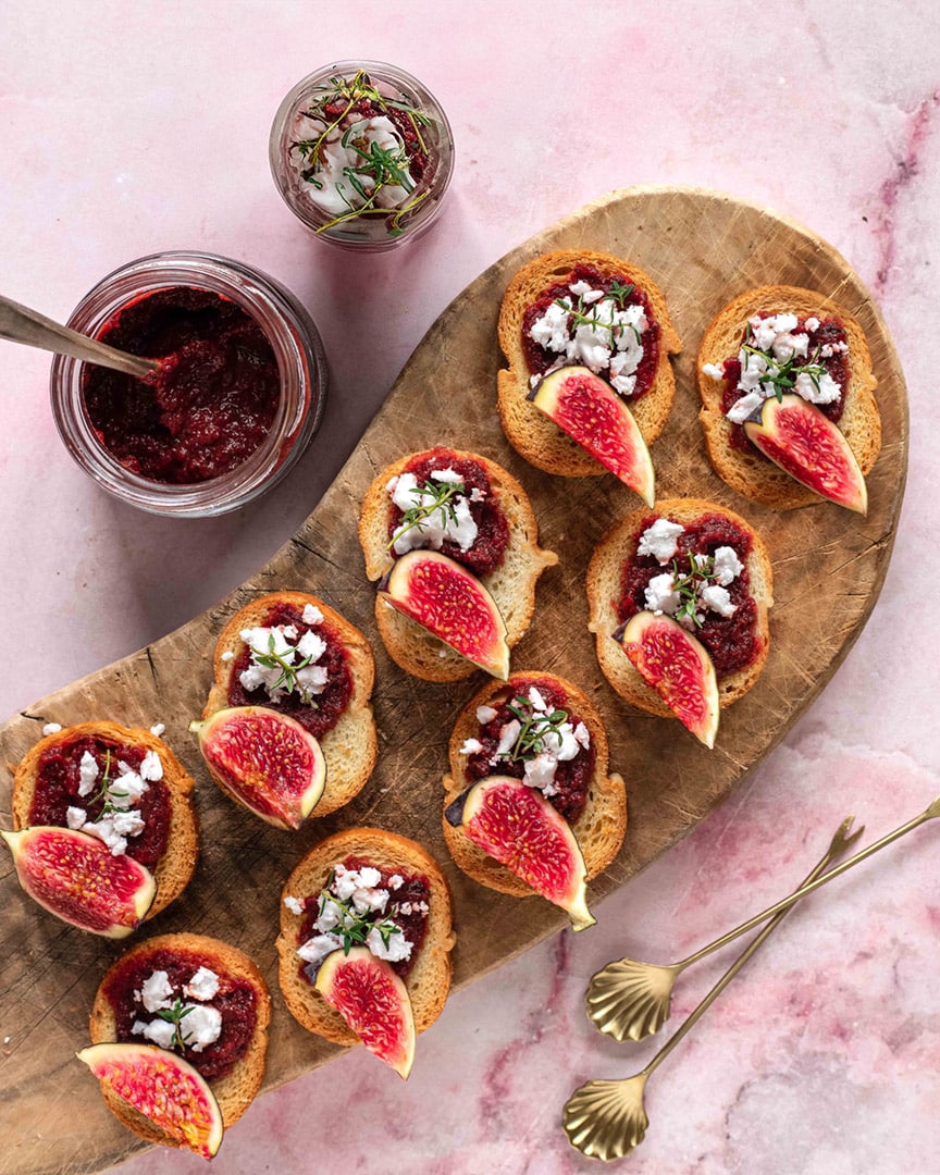 Mini-Canapés auf einer Servierplatte, belegt mit Fleisch, Gemüse und aromatischen Kräutern. Verfeinert mit dem Bio Braten Food Finisher Spices. Würzige Bio-Gewürzsalz mit Pfeffer, Paprika, Chili, Rosmarin und Thymian. 100 % Bio, vegan, ohne Zusatzstoffe.