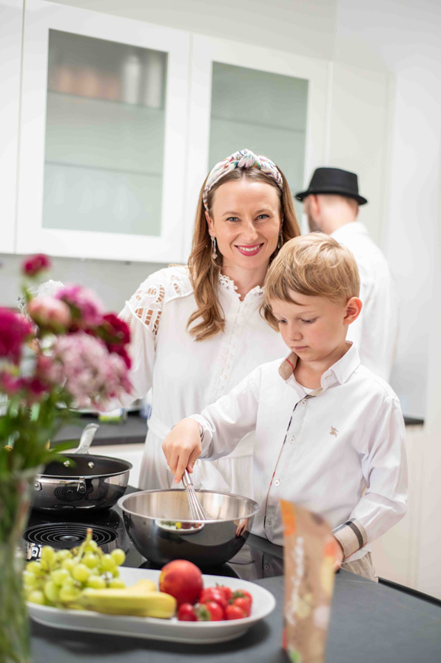 Eine Familie kocht zusammen in der Küche, während die Kinder mithelfen. Ein schöner Moment, der zeigt, wie leicht Kochen mit einfachen Gewürztipps und Tricks sein kann.