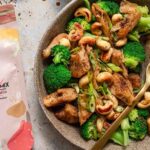 Brokkoli-Pfanne frisch angerichtet. Daneben steht der Bio Espresso BBQ Mix Food Finisher Spices. Die außergewöhnliche Gewürzkombination mit Espresso, Pfeffer, Paprika und Chili verleiht dem Gemüsegericht eine einzigartige, würzig-intensive Note. 100 % Bio, vegan, ohne Zusatzstoffe.