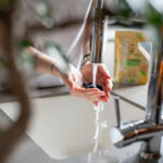 Romy Deckert wäscht frische Blaubeeren in einer Küche, umgeben von weiteren Obst- und Fruchtsorten. Neben ihr liegt der Food Finisher Gewürz-Mix, der für gesunde und schmackhafte Gerichte sorgt. Das Bild symbolisiert gesunde Ernährung und bewussten Genuss.