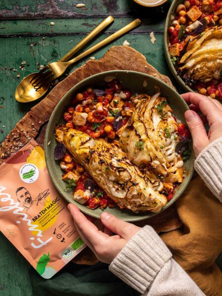 Gegrillter Spitzkohl auf Kichererbsen-Tomaten-Eintopf, verfeinert mit dem Bio Braten-Magic Food Finisher Spices. Im Bild: goldbraun gegrillter Spitzkohl auf aromatischem Eintopf, bestreut mit Bio-Gewürzmischung aus Sonnenflocken-Salz, Paprika, grünem Pfeffer, Chipotle-Chili und Espresso. 100 % Bio, vegan, ohne Zusatzstoffe.