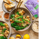 Zwei Schalen mit Nudeln, Brokkolini, Pinienkernen und Zitronensauce, daneben geröstetes Brot, Parmesan und die Verpackung des Bio Antipasti Food Finishers.